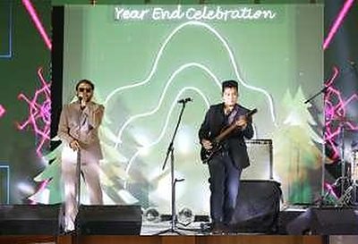 Live band performing beneath a 'Year End Celebration' neon backdrop at the BCG party