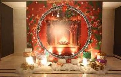 Festive red and green photo backdrop with a wreath and gift display