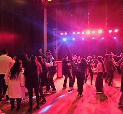 Evening celebration on the dance floor under red and blue stage lighting