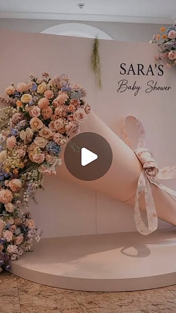 Pastel baby shower with an oversized bouquet installation behind the dais